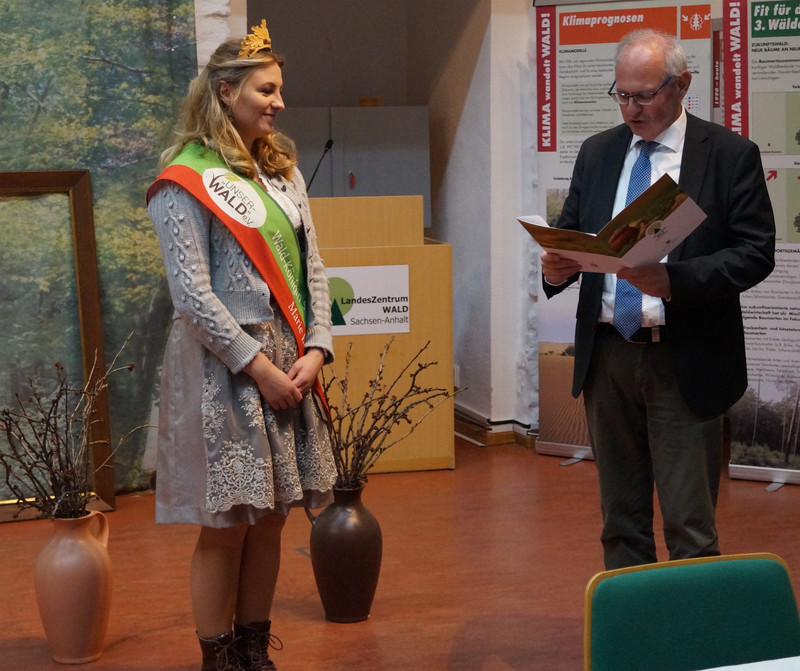 Staatssekretär Gert Zender überreicht Waldkönigin Marie I ihr Zertifikat Waldpädagogik